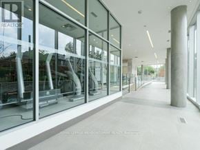 Toronto (Woodbine Corridor) condo for rent - A long hallway with glass doors and a white floor.