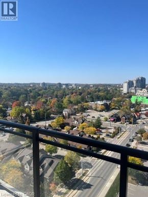 Waterloo condo for rent - A view from a balcony overlooking a city with a highway and buildings.