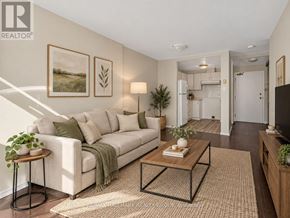 Ottawa condo for rent - A living room with a white couch, a coffee table, and a lamp.