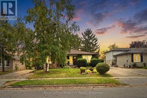 Guelph (Grange Road) apartment for rent - A house with a lawn and trees in front of it.