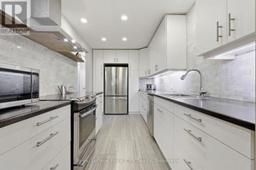 Guelph (Grange Road) apartment for rent - A modern kitchen with white cabinets and stainless steel appliances.