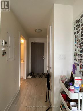 Toronto (Waterfront Communities) condo for rent - A hallway with a refrigerator covered in magnets and a door with a black and white checkered floor.