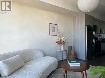 Toronto (Islington-City Centre West) condo for rent - A living room with a white couch and a small table with a book on it.