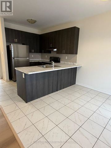 Centre Wellington (Fergus) apartment for rent - A kitchen with a refrigerator, sink, and cabinets.