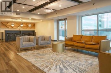 Kitchener condo for rent - A living room with a couch, chairs, and a coffee table.