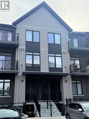 Guelph (Riverside Park) townhouse for rent - A modern two-story building with a balcony on the second floor.