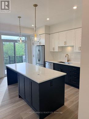 Guelph (Riverside Park) townhouse for rent - A kitchen with a white countertop and dark cabinets.