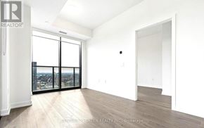 Kitchener condo for rent - A spacious room with a view of the city through the windows.