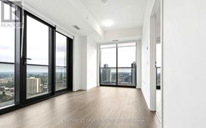 Kitchener condo for rent - A spacious room with a view of the city through large windows.