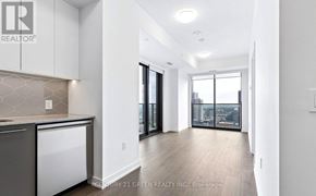 Kitchener condo for rent - A modern kitchen with white cabinets and a marble backsplash.