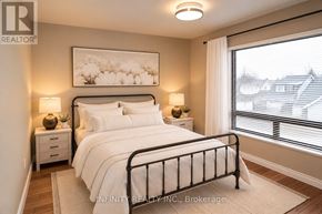 Windsor apartment for rent - A bedroom with a large bed, two nightstands, and a window with blinds.