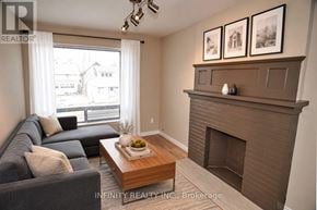 Windsor apartment for rent - A living room with a grey couch, a coffee table, and a fireplace.