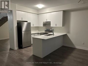 Oshawa (Donevan) townhouse for rent - A kitchen with a refrigerator, stove, and cabinets.