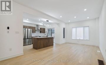 Barrie apartment for rent - A spacious kitchen with a center island and a dining area with a table and chairs.