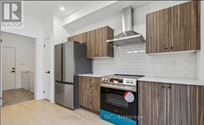 Barrie apartment for rent - A modern kitchen with wooden cabinets and a stainless steel refrigerator.