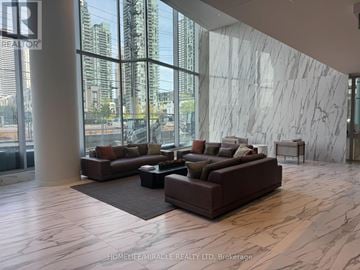 Mississauga (City Centre) condo for rent - A living room with brown couches and a marble wall.