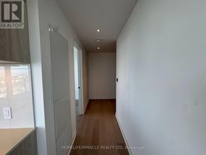Mississauga (City Centre) condo for rent - A long hallway with a white wall and wooden floor.