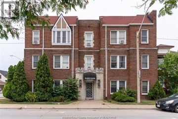 Windsor apartment for rent - A brick building with a black car parked in front.