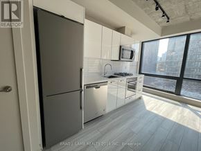 Toronto (Waterfront Communities) condo for rent - A modern kitchen with a refrigerator, stove, and oven.