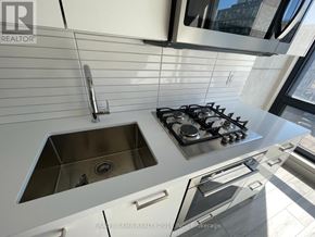Toronto (Waterfront Communities) condo for rent - A modern kitchen with a stainless steel stove and sink.