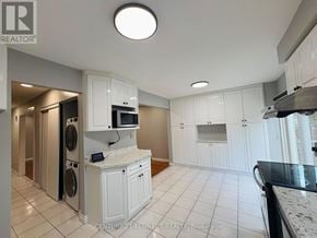 Markham (Milliken Mills West) apartment for rent - A kitchen with white cabinets and a marble countertop.