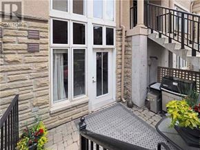 Toronto (Niagara) townhouse for rent - A stone building with a glass door and windows.