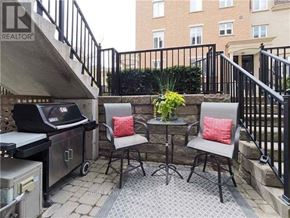 Toronto (Niagara) townhouse for rent - A patio with a table and chairs and a grill.