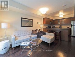 Toronto (Niagara) townhouse for rent - A living room with a grey couch, a coffee table, and a framed picture on the wall.