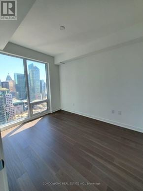 Toronto (Waterfront Communities) condo for rent - Empty room with a view of the cityscape outside the window.