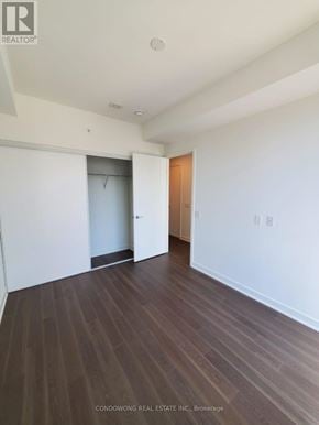 Toronto (Waterfront Communities) condo for rent - A room with white walls and wood flooring, with a door on the right and a closet on the left.