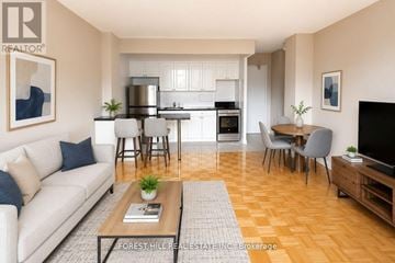 Toronto (North St. James Town) house for rent - A well-lit, modern living room with a kitchen in the background.