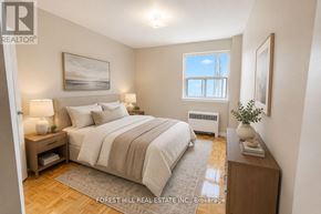 Toronto (North St. James Town) house for rent - A bedroom with a large bed, a nightstand, and a window.