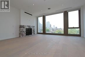 Toronto (Annex) condo for rent - A large, empty room with a fireplace and a view of the city.