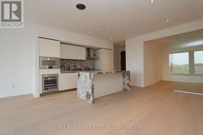 Toronto (Annex) condo for rent - A modern kitchen with a marble island and wooden floors.