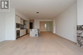 Toronto (Annex) condo for rent - A spacious room with wooden flooring and a white ceiling.