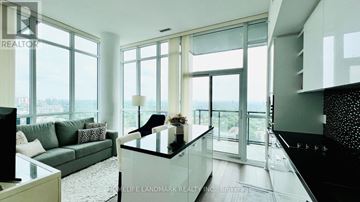 Toronto (Annex) condo for rent - A modern living room with a glass table and a couch.