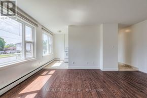 Whitby (Downtown Whitby) multi-family for rent - A room with wooden flooring and white walls, with a window on the left side.