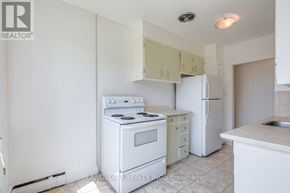 Whitby (Downtown Whitby) multi-family for rent - A white kitchen with a stove, oven, and refrigerator.