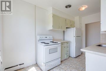 Whitby (Downtown Whitby) multi-family for rent - A white kitchen with a stove, oven, and refrigerator.
