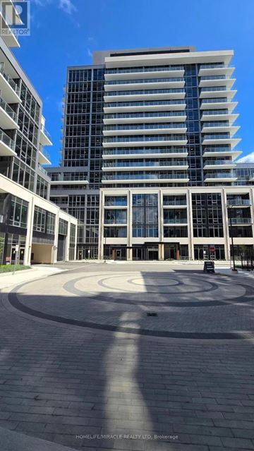Milton (Tm Timberlea) condo for rent - A modern building with a glass facade and a circular courtyard in front.