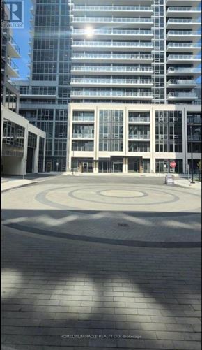 Milton (Tm Timberlea) condo for rent - A large building with a glass facade and a circular courtyard in front.