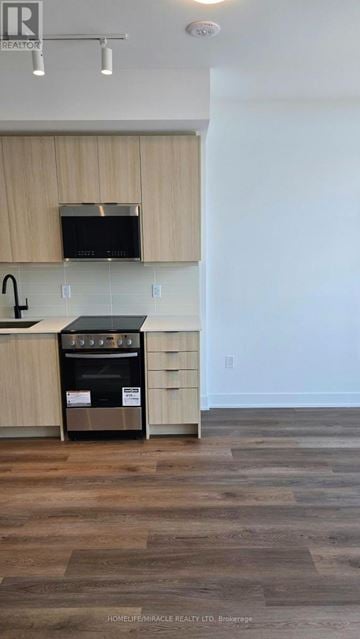 Milton (Tm Timberlea) condo for rent - A kitchen with a black oven and wooden cabinets.