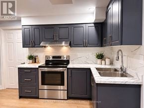 Oakville (Ga Glen Abbey) apartment for rent - A kitchen with dark cabinets and a stainless steel stove top.