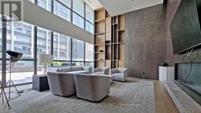 Toronto (Bay Street Corridor) condo for rent - A modern living room with a large window and a grey sofa.