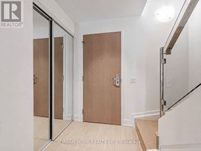 Toronto (Bay Street Corridor) condo for rent - A hallway with a wooden floor and white walls leading to a staircase.