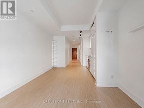 Toronto (Bay Street Corridor) condo for rent - A long hallway with white walls and wood flooring.
