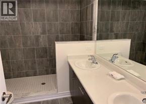 Brantford townhouse for rent - A bathroom with a sink, mirror, and shower.