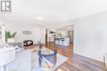 Stratford apartment for rent - A modern living room with a white sofa and a black chair.