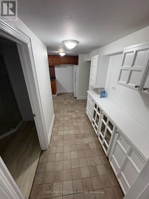 Newmarket (Bristol-London) apartment for rent - A long hallway with white walls and brown tiled floors.