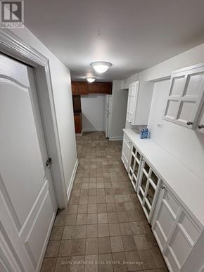 Newmarket (Bristol-London) apartment for rent - A hallway with white walls and brown tile flooring.